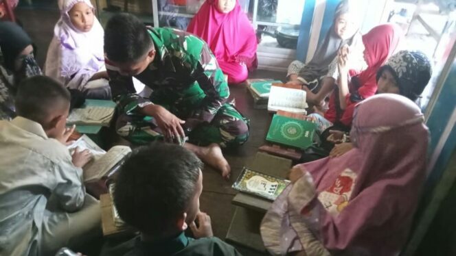 
					Poto: Seorang prajurit Pos Sei Kaca Satgas Batalyon Arhanud 8/MBC sedang mengajari anak-anak mengaji di rumah bapak pandi Kelurahan Nunukan Utara. Kamis (26/10/23). (DOK. Istimewa) 