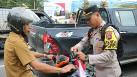 Foto: Penajam Paser Utara (PPU) melaksanakan aksi simpatik dengan membagikan dan memasang Bendera Merah Putih kepada para pengendara di Km 09 Kelurahan Nipah-Nipah (Dok. Polres PPU)