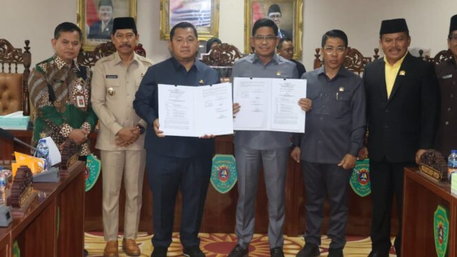 
					Foto: Bupati Penajam Paser Utara, Mudyat Noor, bersama Ketua DPRD PPU, Raup Muin, menunjukkan berkas Nota Kesepakatan Bersama KUA-PPAS Tahun Anggaran 2026 usai penandatanganan dalam Rapat Paripurna DPRD. Turut hadir Wakil Bupati PPU, Abdul Waris Muin, Sekda PPU Tohar, serta unsur pimpinan DPRD dan jajaran terkait. (Dok. Humas PPU)