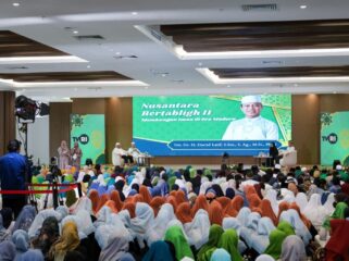 Foto: Ribuan peserta memadati kegiatan Nusantara Bertabligh II di Ibu Kota Nusantara. Acara yang digelar di sebuah aula besar ini menampilkan seorang penceramah di atas panggung serta tayangan visual bertema keagamaan di layar utama, dengan tim produksi TVRI turut melakukan peliputan. (Dok. Humas OIKN)